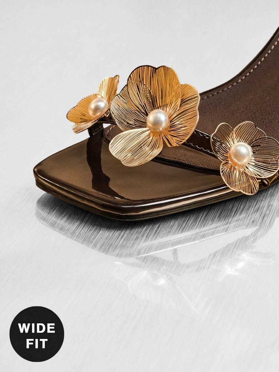 Women's metallic gold wide-fit high heeled sandals featuring stiletto heels, open toe straps, and elegant floral appliques.