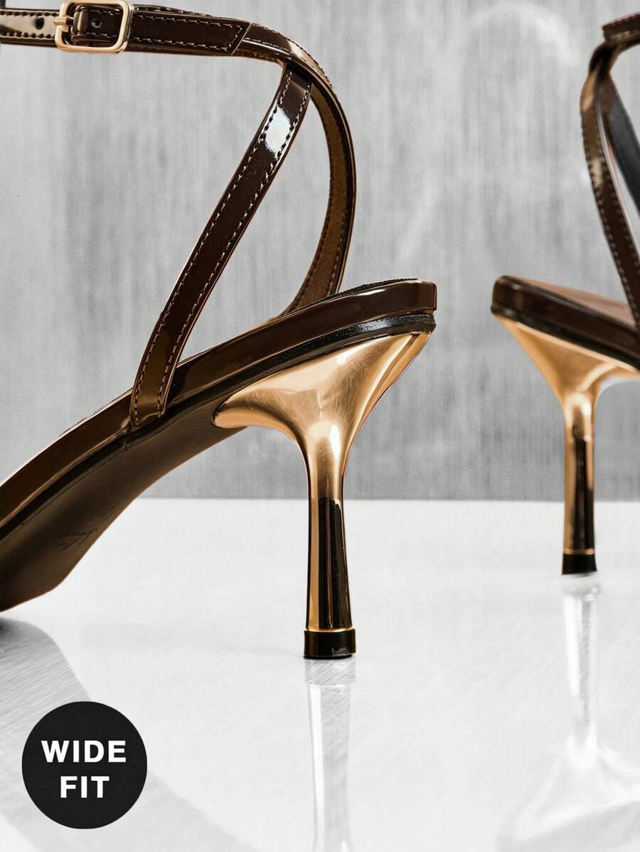 Women's metallic gold wide-fit high heeled sandals featuring stiletto heels, open toe straps, and elegant floral appliques.