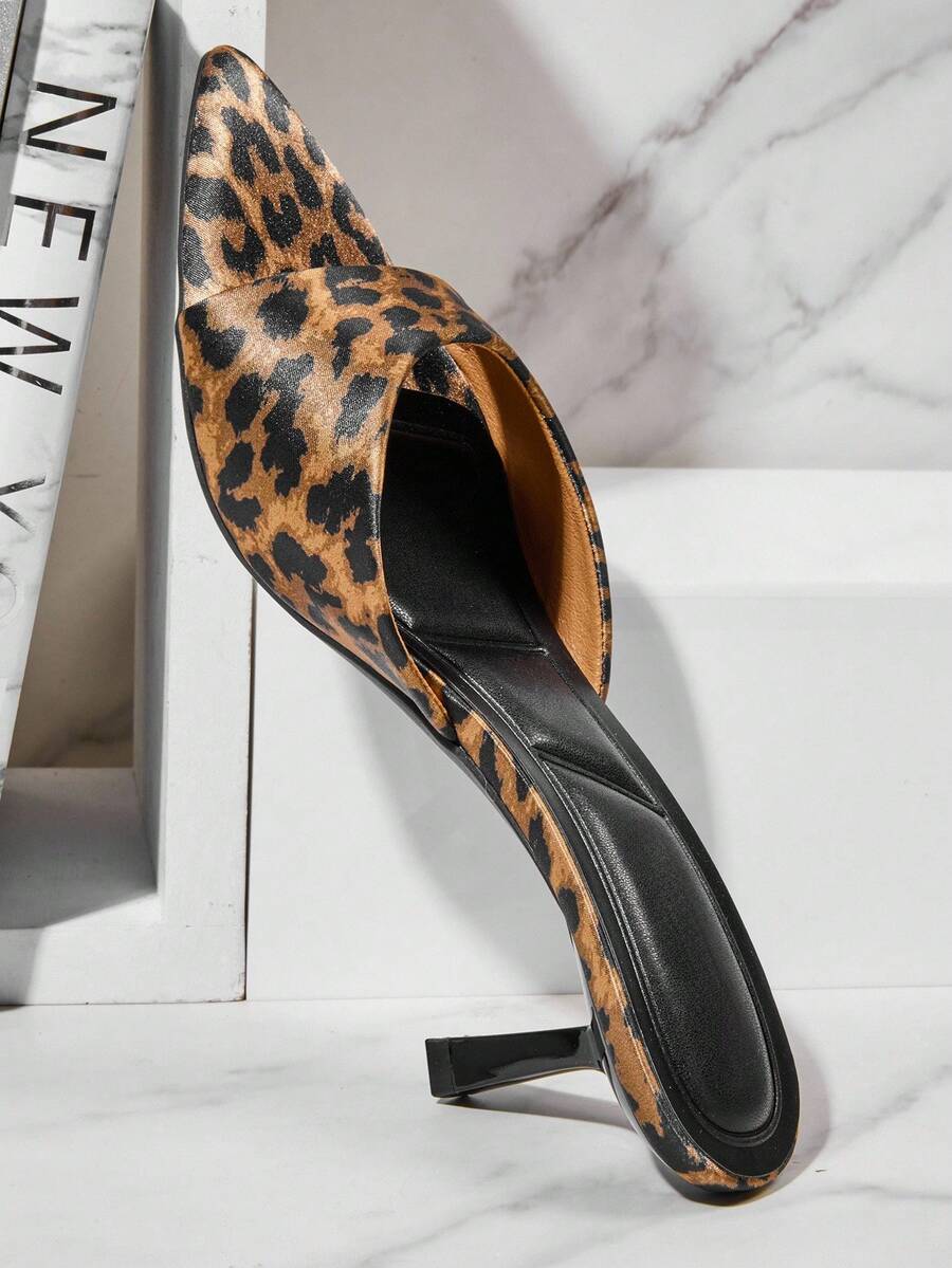 Black pointy toe kitten heel shoes for women featuring a sleek cut out mule design and glossy patent leather finish.