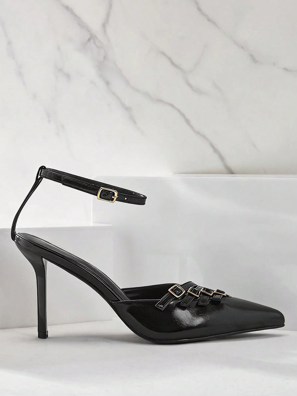 Women's pointed toe stiletto heel slingback pumps in chocolate brown with double metal buckle strap details.