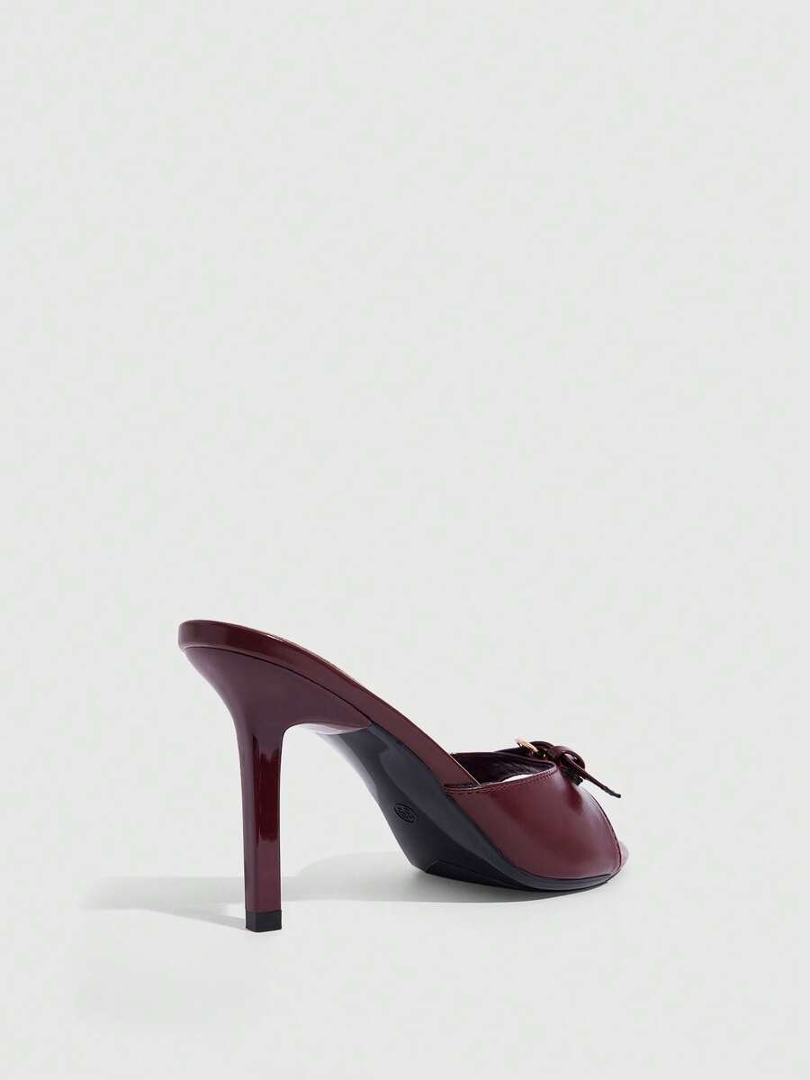 Elegant burgundy high heel slingback sandals with an open toe and round buckle strap.