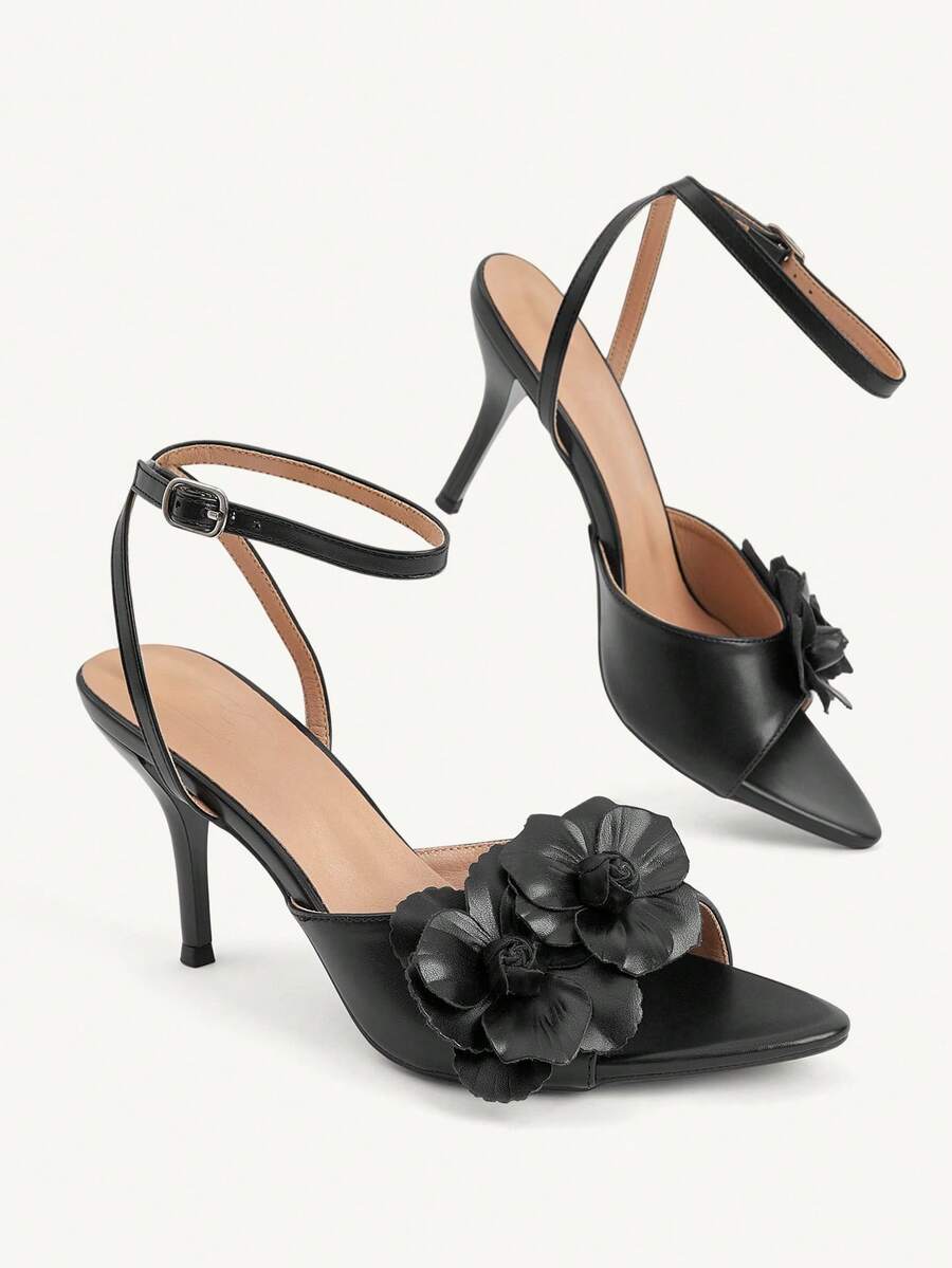 Champagne stiletto high heel sandals featuring a flower detail, open toe, and buckle back strap.