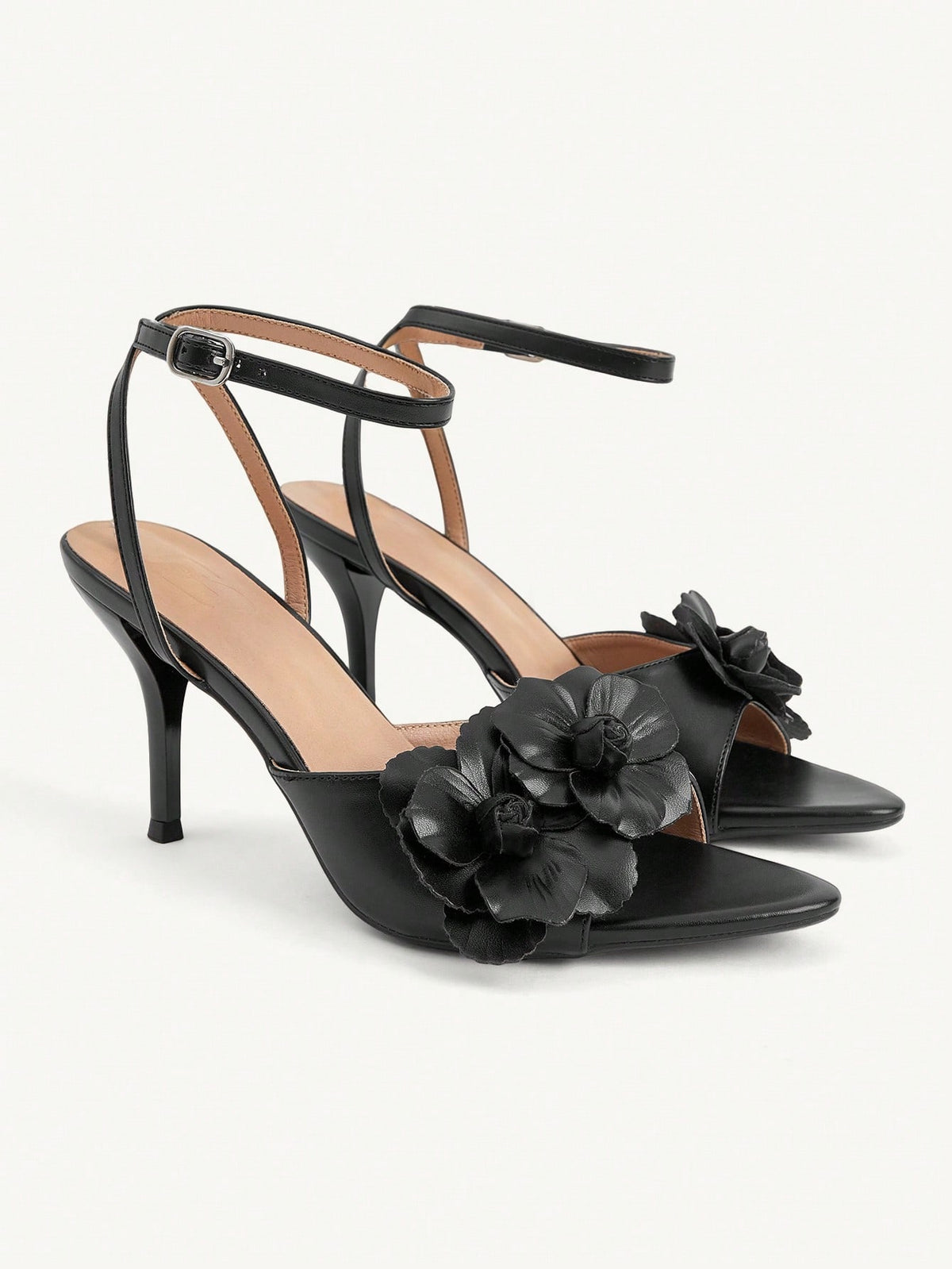 Champagne stiletto high heel sandals featuring a flower detail, open toe, and buckle back strap.