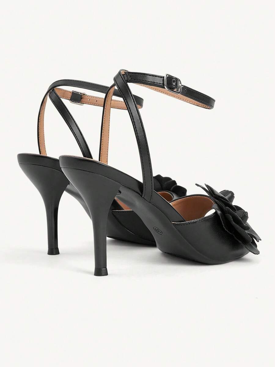 Champagne stiletto high heel sandals featuring a flower detail, open toe, and buckle back strap.