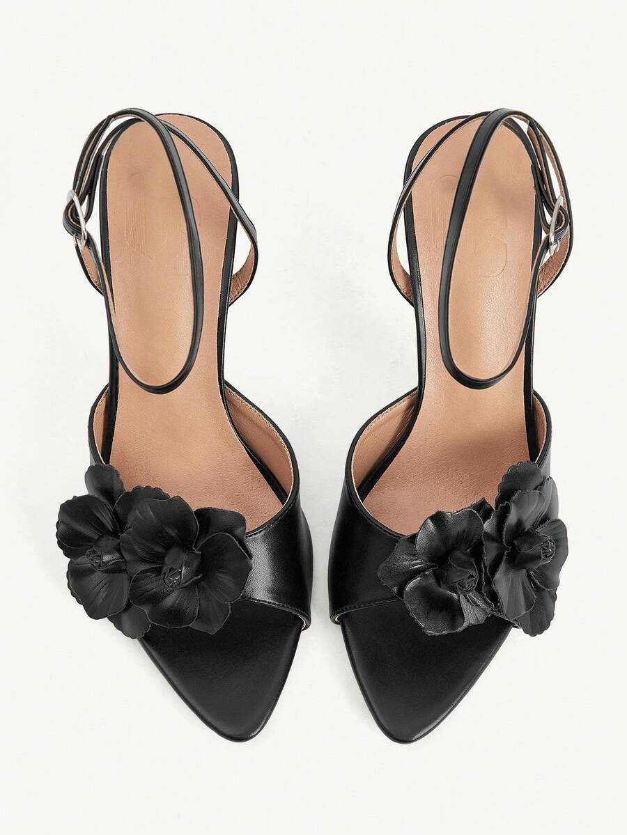 Champagne stiletto high heel sandals featuring a flower detail, open toe, and buckle back strap.