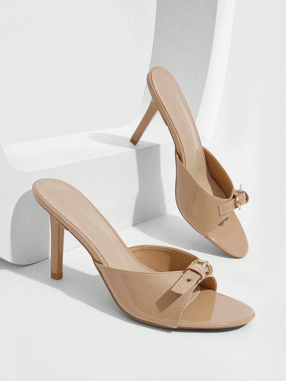 Elegant burgundy high heel slingback sandals with an open toe and round buckle strap.