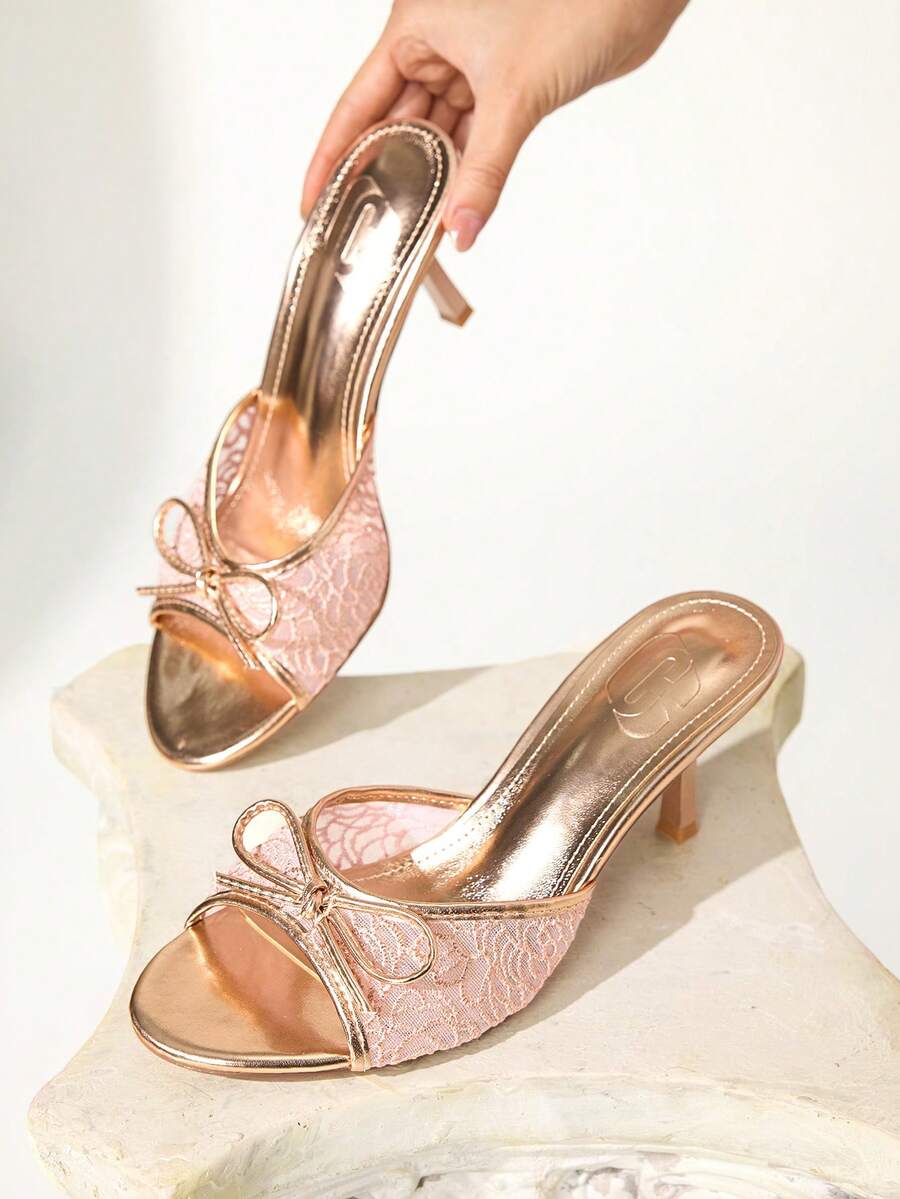 Open toe high heel slide sandals featuring lace details and a bow accent on the upper strap.