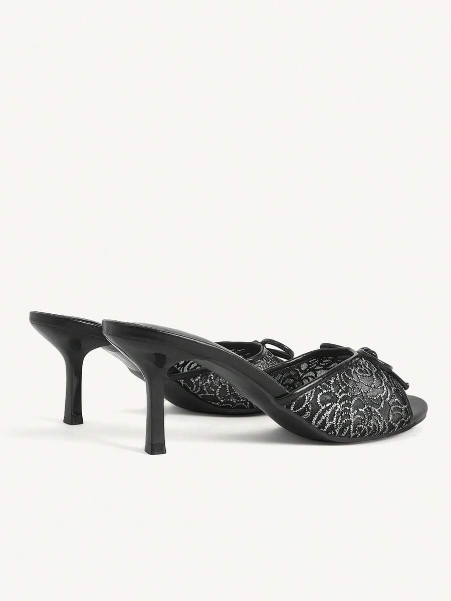 Open toe high heel slide sandals featuring lace details and a bow accent on the upper strap.