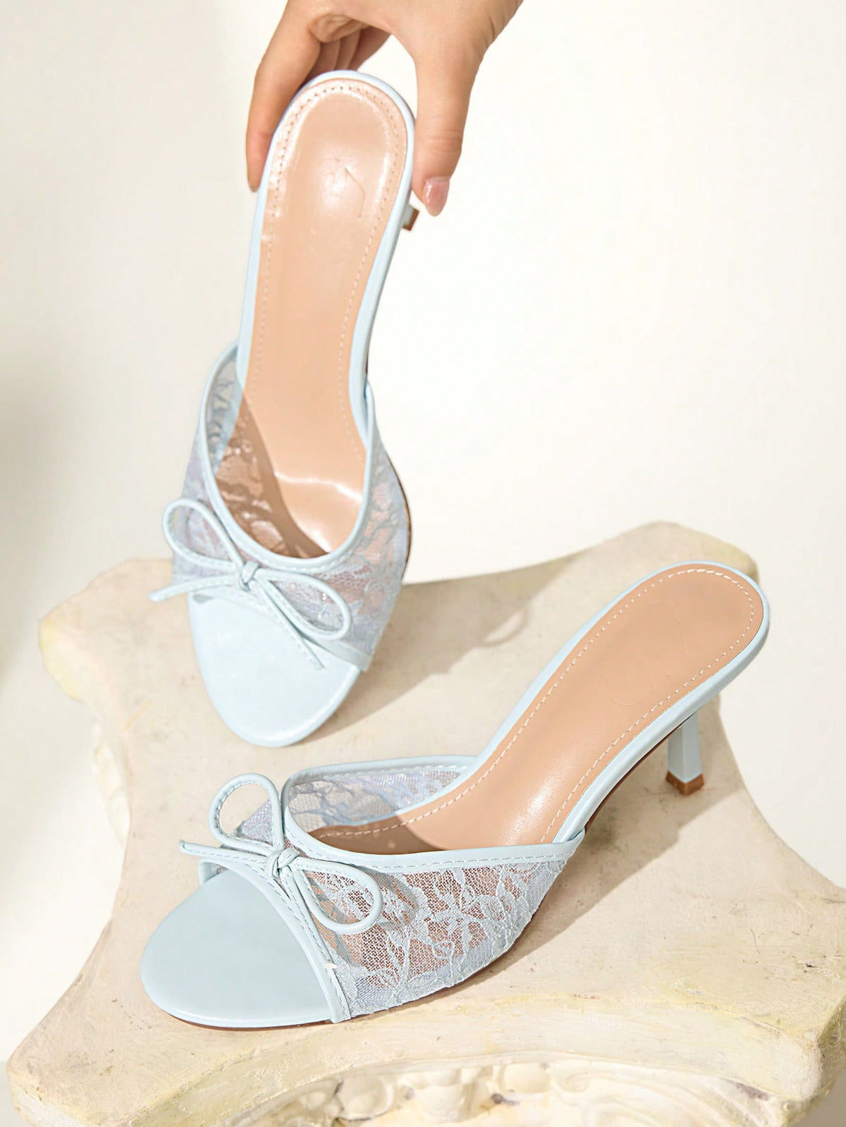 Open toe high heel slide sandals featuring lace details and a bow accent on the upper strap.