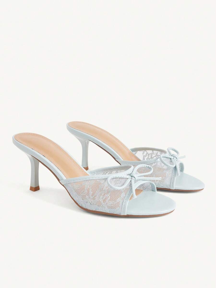 Open toe high heel slide sandals featuring lace details and a bow accent on the upper strap.