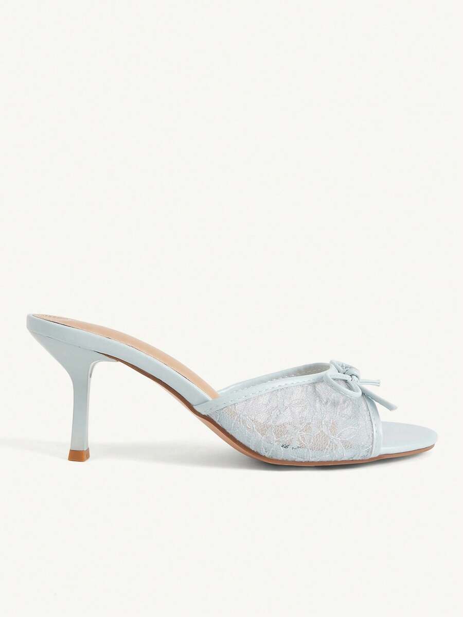 Open toe high heel slide sandals featuring lace details and a bow accent on the upper strap.