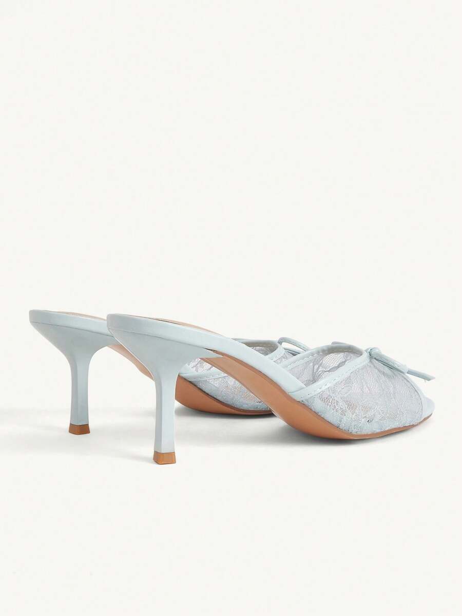 Open toe high heel slide sandals featuring lace details and a bow accent on the upper strap.
