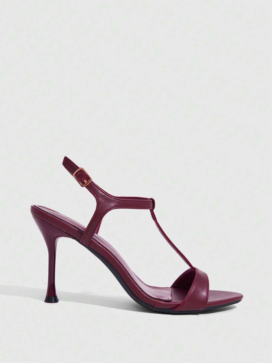 Women's open toe stiletto high heel sandals with T-strap design and adjustable ankle buckle closure in sleek PU leather.