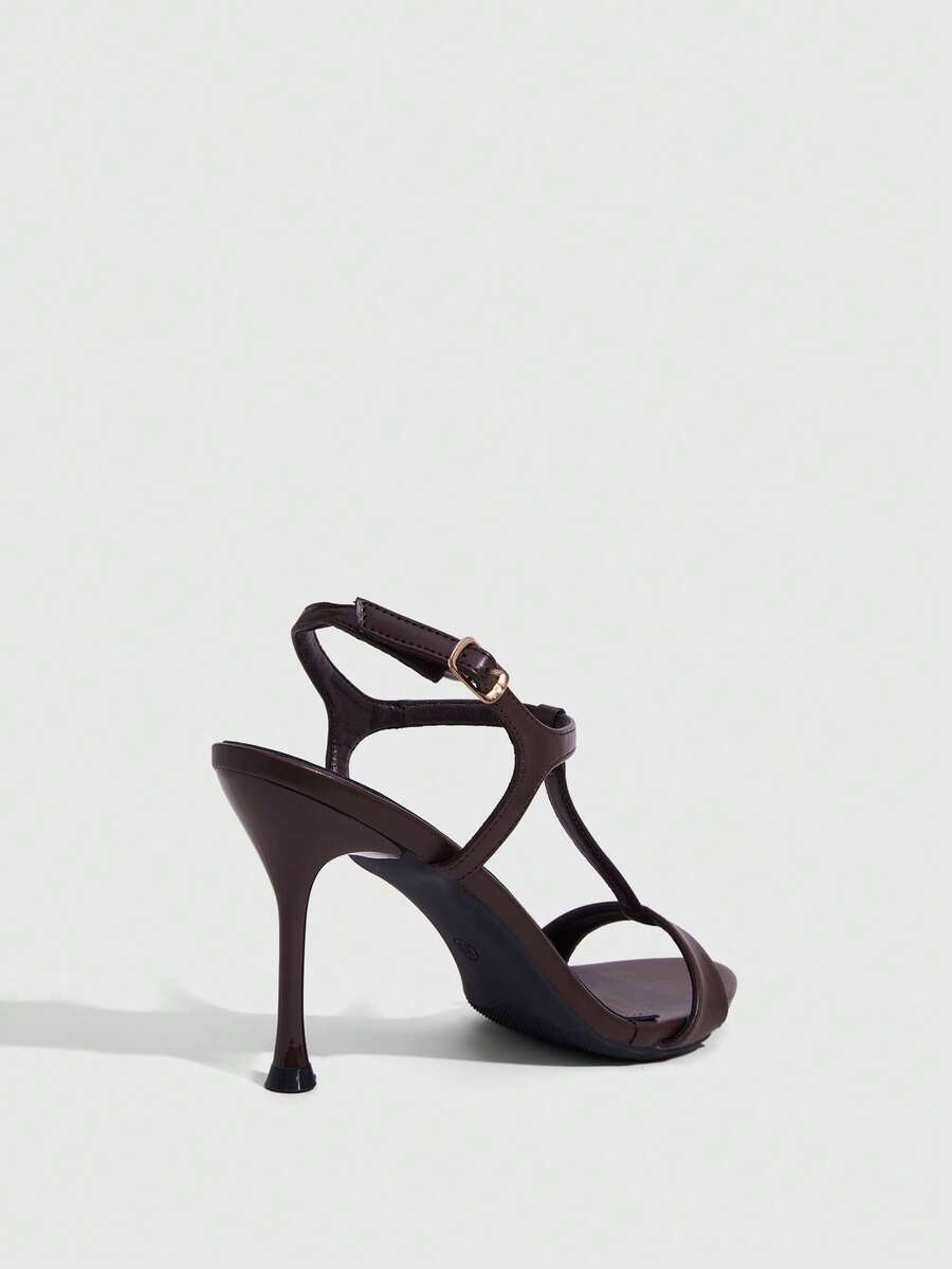 Women's open toe stiletto high heel sandals with T-strap design and adjustable ankle buckle closure in sleek PU leather.