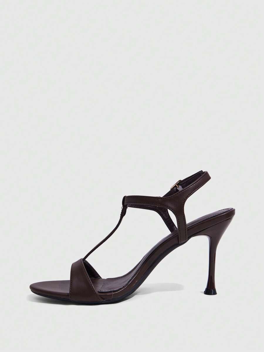 Women's open toe stiletto high heel sandals with T-strap design and adjustable ankle buckle closure in sleek PU leather.