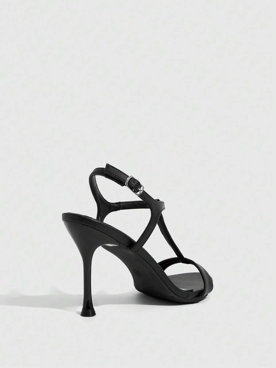 Women's open toe stiletto high heel sandals with T-strap design and adjustable ankle buckle closure in sleek PU leather.