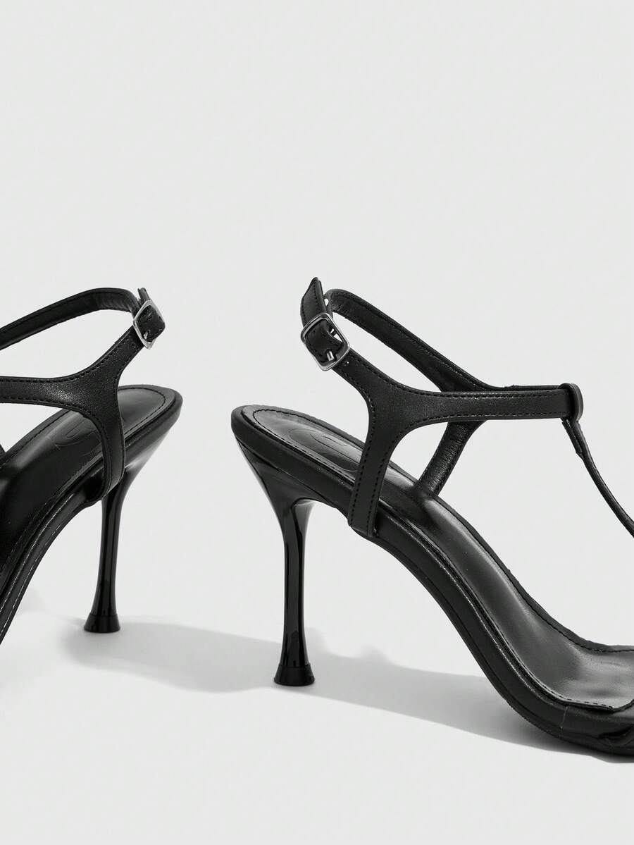 Women's open toe stiletto high heel sandals with T-strap design and adjustable ankle buckle closure in sleek PU leather.