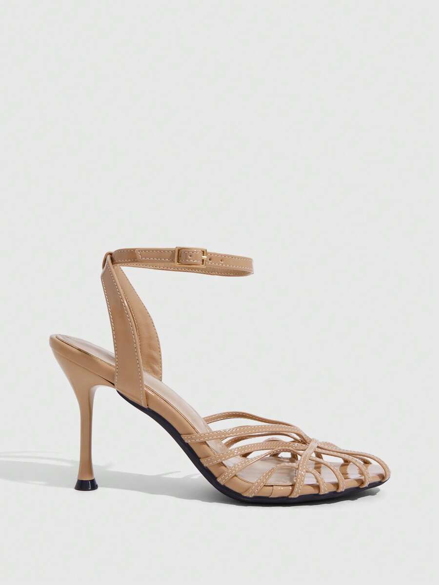 Women's glossy silver open-toed sandals with thin pyramid heel and strappy ribbon details.