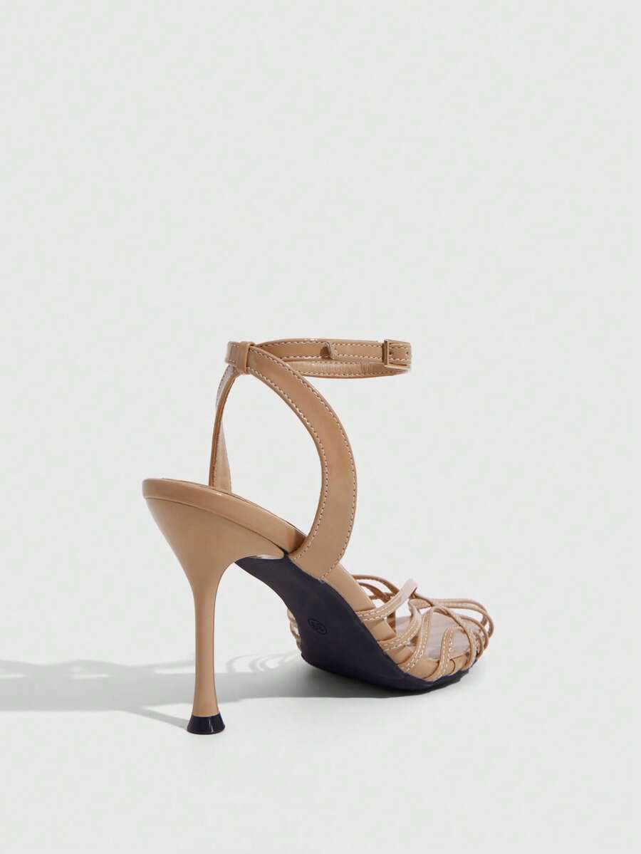 Women's glossy silver open-toed sandals with thin pyramid heel and strappy ribbon details.