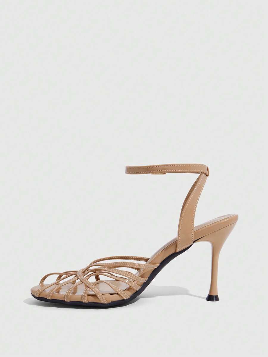 Women's glossy silver open-toed sandals with thin pyramid heel and strappy ribbon details.