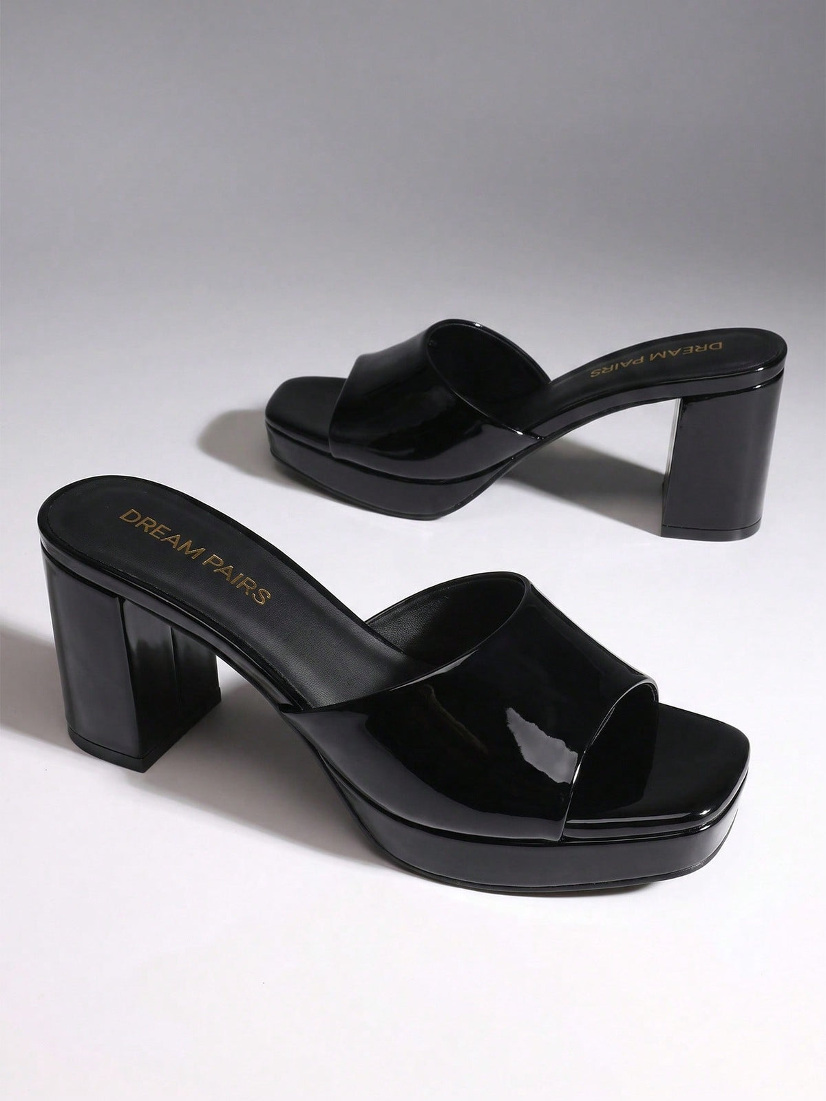 Women's minimalist open toe mule sandals featuring a chunky low heel, wide single strap, and slip-on design.