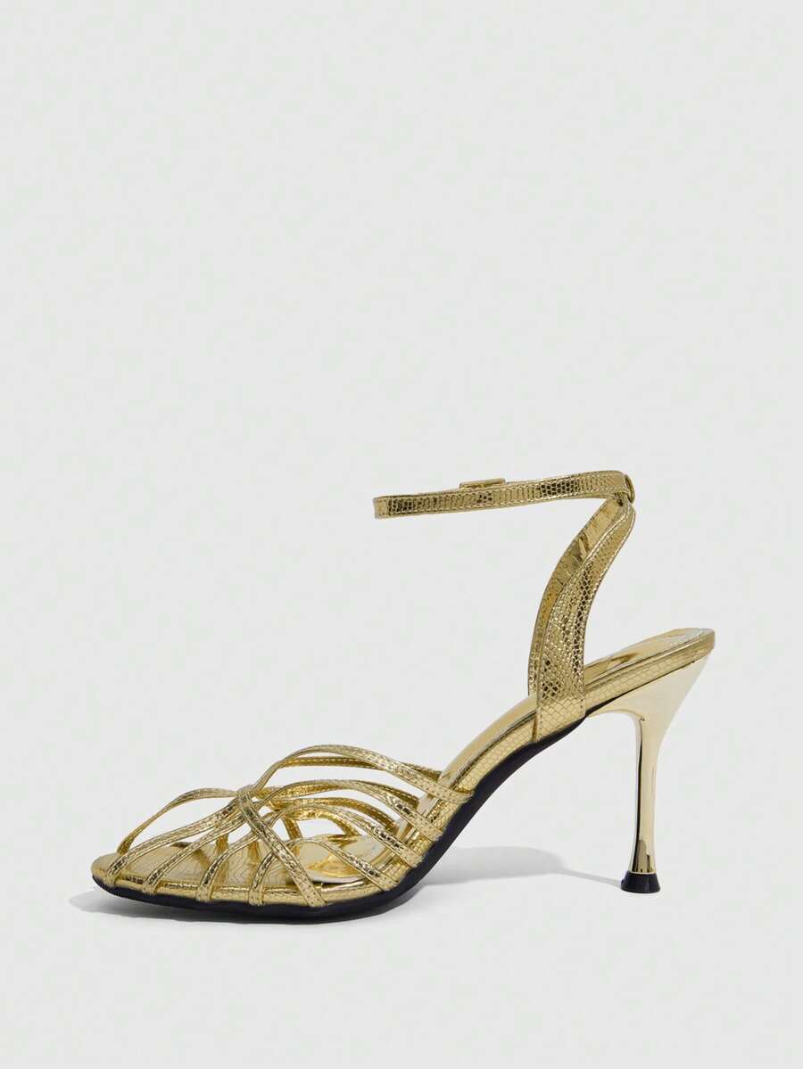 Women's glossy silver open-toed sandals with thin pyramid heel and strappy ribbon details.