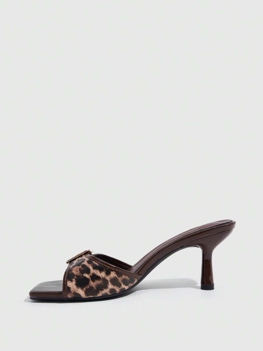 Beige women's slip-on kitten heel slide sandals featuring an accent buckle with grommet eyelets.