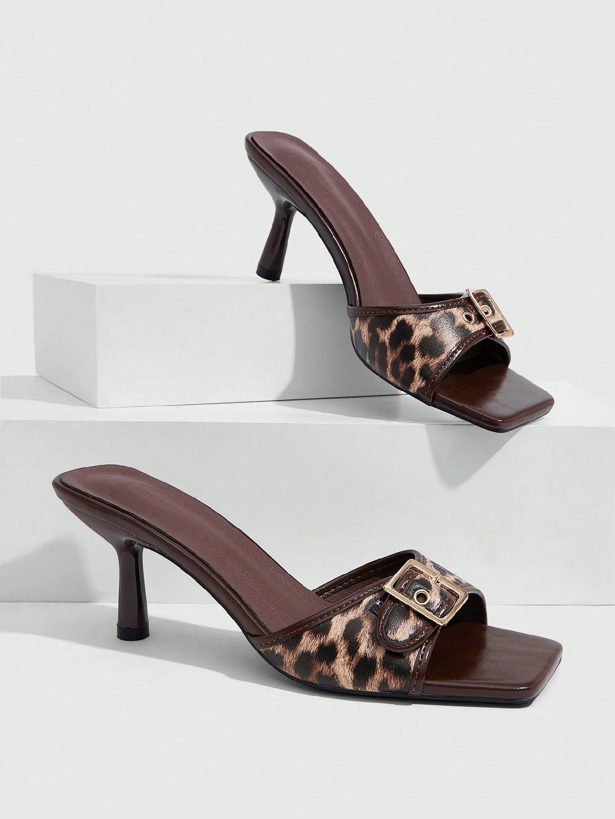 Beige women's slip-on kitten heel slide sandals featuring an accent buckle with grommet eyelets.