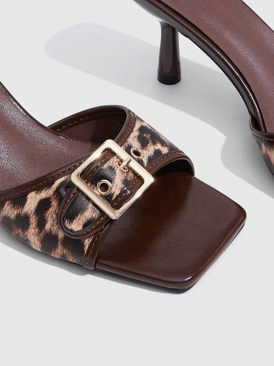 Beige women's slip-on kitten heel slide sandals featuring an accent buckle with grommet eyelets.
