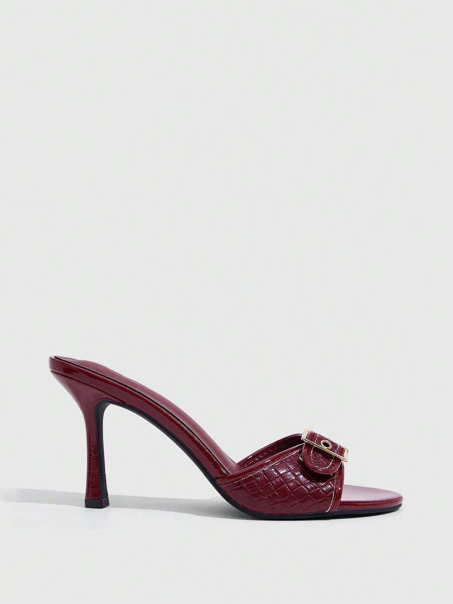 Women's brown leopard print high heel mule sandals with gold-tone buckle and grommet eyelet accents.