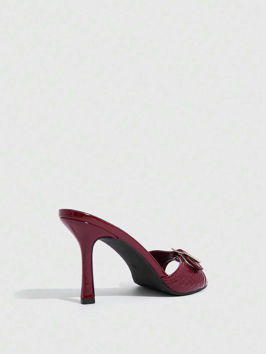 Women's brown leopard print high heel mule sandals with gold-tone buckle and grommet eyelet accents.