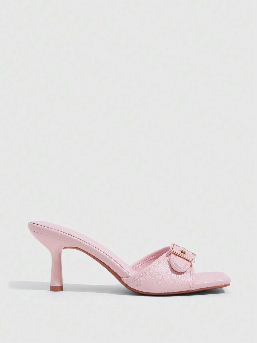Beige women's slip-on kitten heel slide sandals featuring an accent buckle with grommet eyelets.
