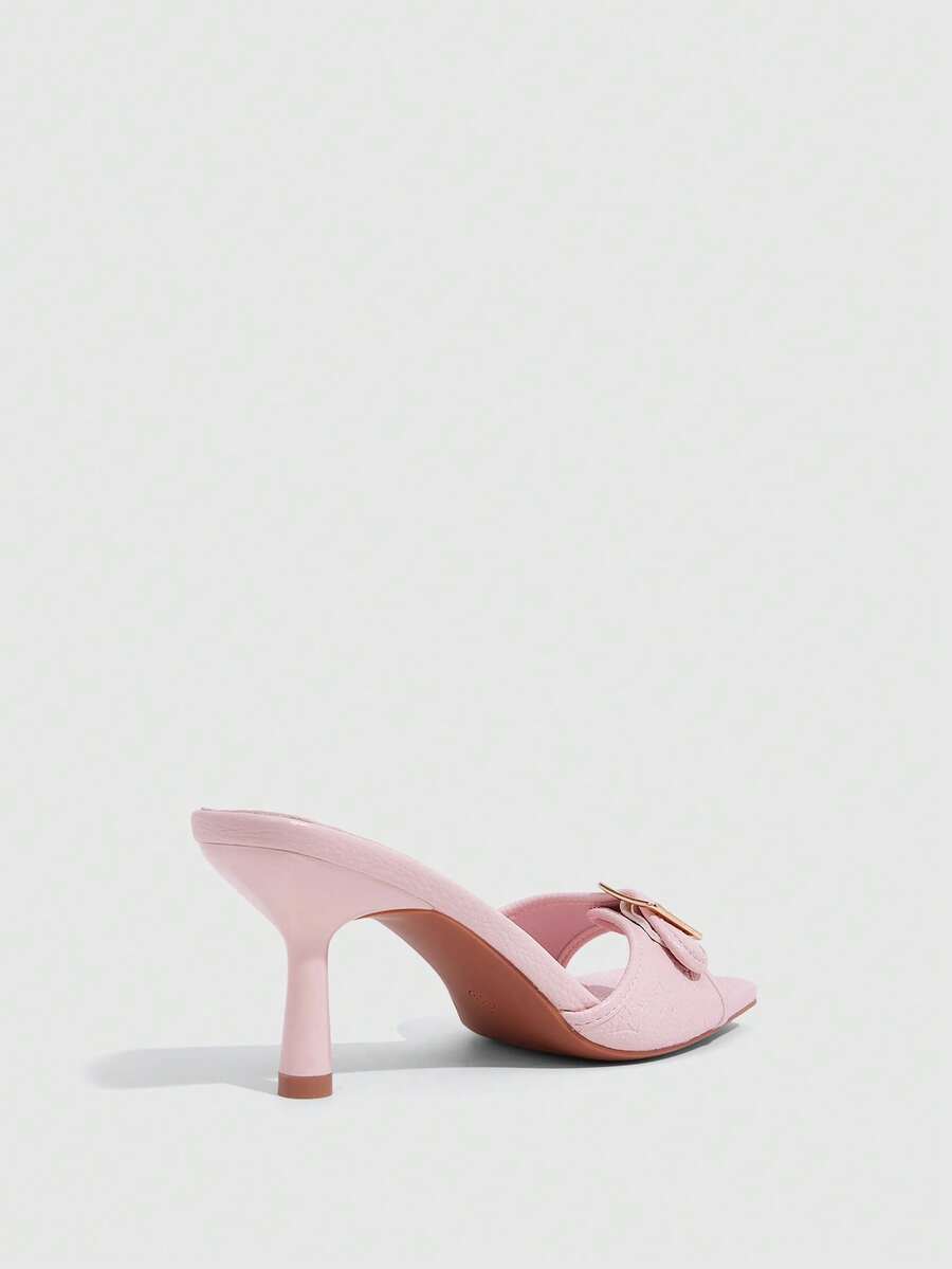 Beige women's slip-on kitten heel slide sandals featuring an accent buckle with grommet eyelets.