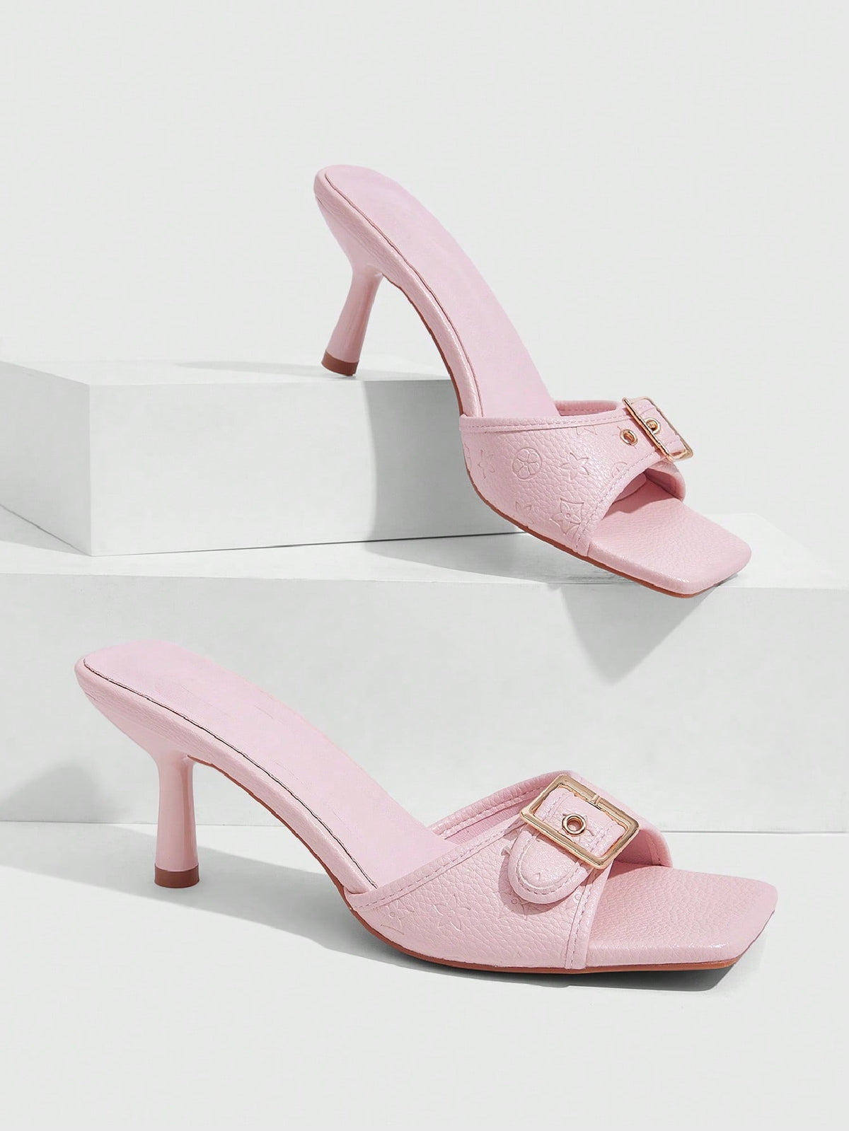 Beige women's slip-on kitten heel slide sandals featuring an accent buckle with grommet eyelets.