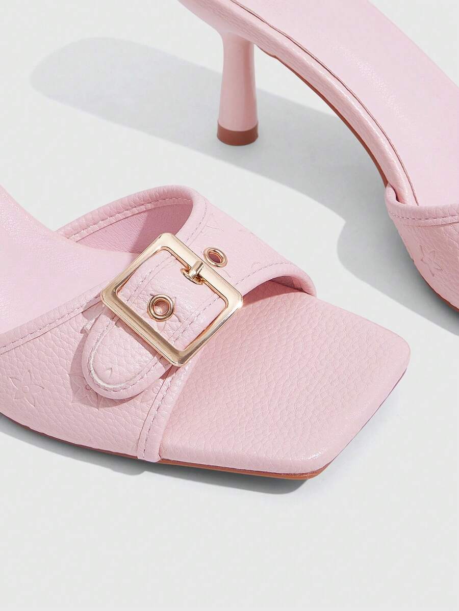 Beige women's slip-on kitten heel slide sandals featuring an accent buckle with grommet eyelets.