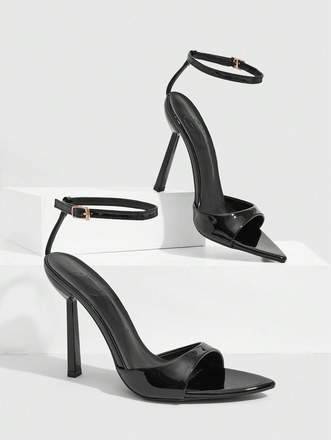 Women's black patent leather high heels sandals featuring lace up ankle straps, open toe, and stiletto heel.