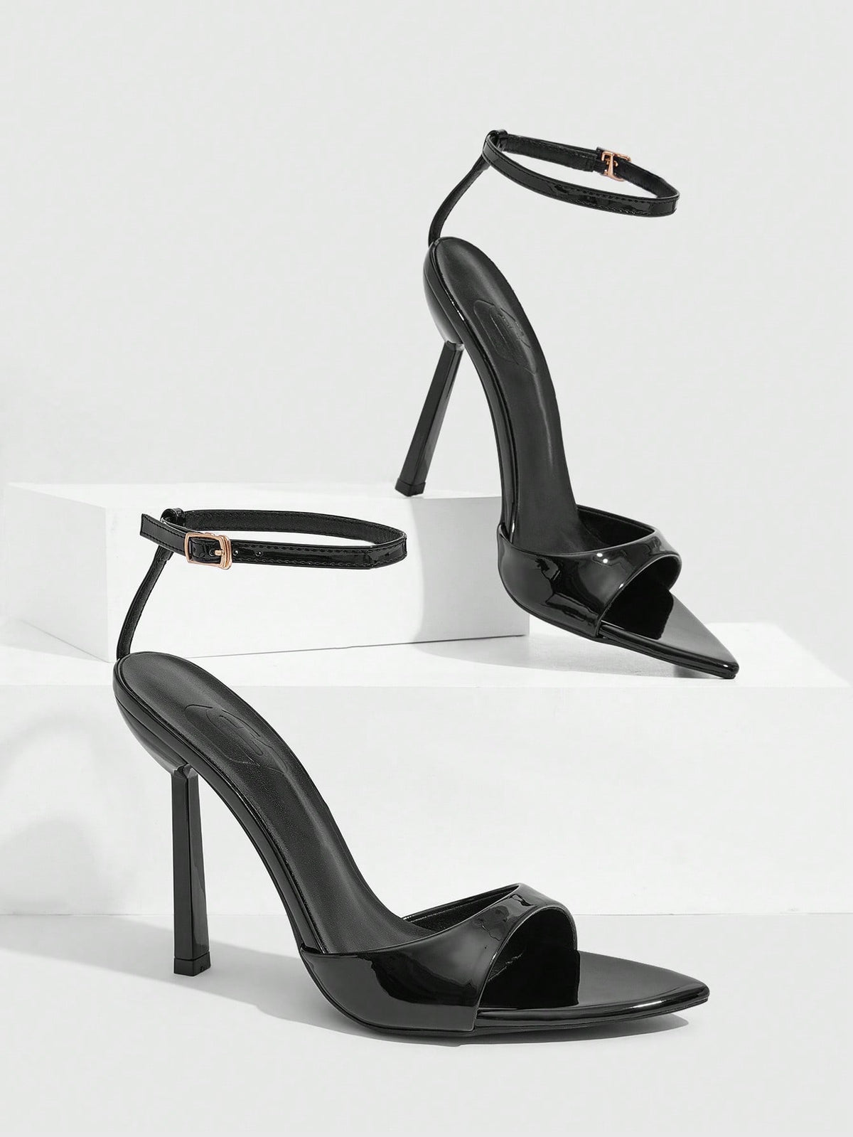 Women's black patent leather high heels sandals featuring lace up ankle straps, open toe, and stiletto heel.