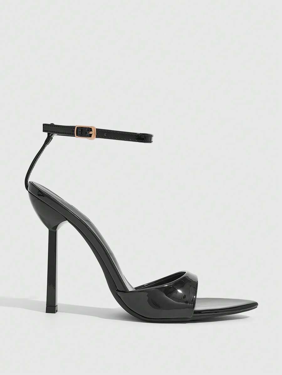 Women's black patent leather high heels sandals featuring lace up ankle straps, open toe, and stiletto heel.