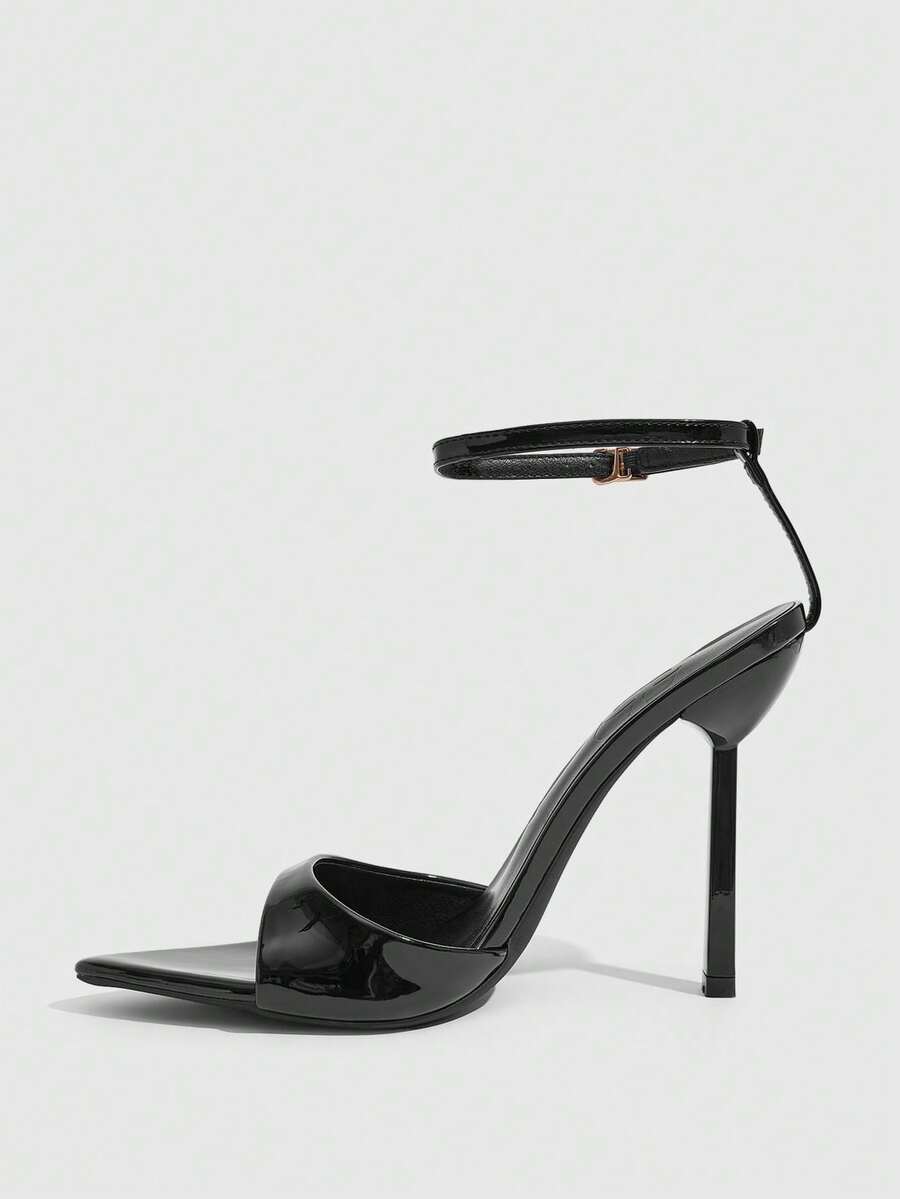 Women's black patent leather high heels sandals featuring lace up ankle straps, open toe, and stiletto heel.