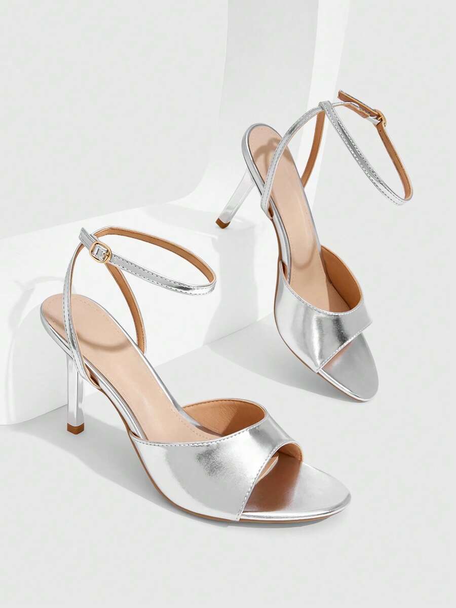 Pair of women's black high heel sandals with open toe design, slim stiletto heel, and adjustable ankle buckle strap.