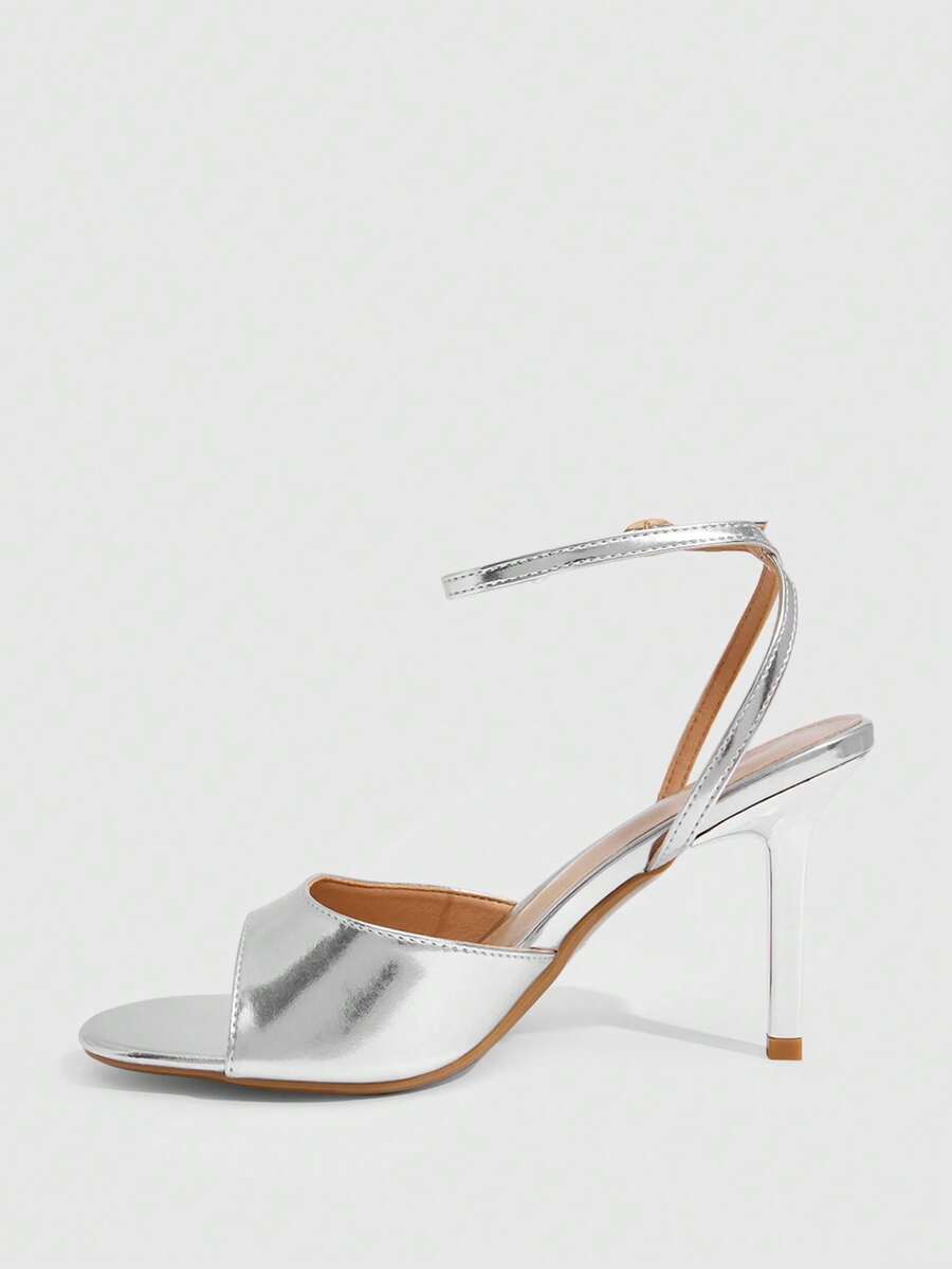 Pair of women's black high heel sandals with open toe design, slim stiletto heel, and adjustable ankle buckle strap.