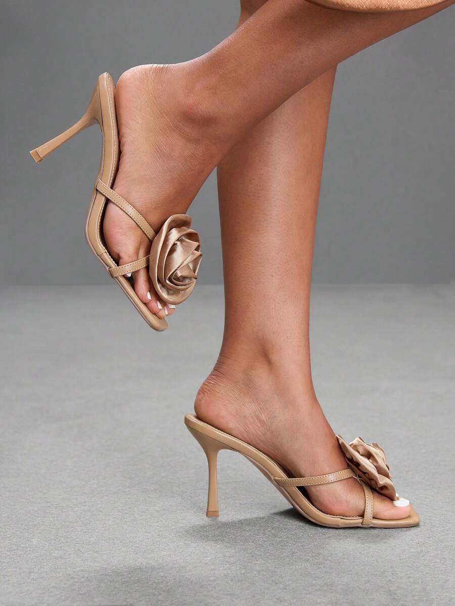 Women's open toe satin slip-on heeled sandals featuring an elegant flower accent and high stiletto heel.