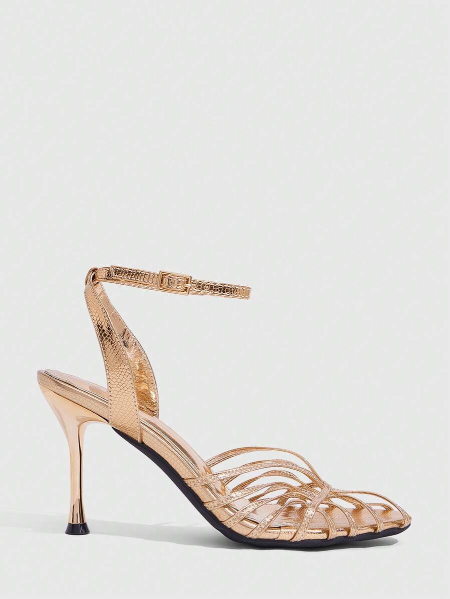 Women's glossy silver open-toed sandals with thin pyramid heel and strappy ribbon details.