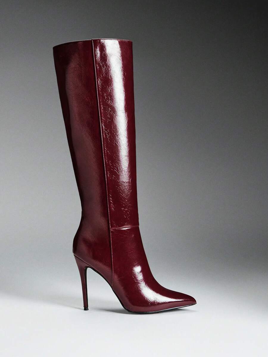 Women's black pointy toe stiletto heel boots featuring a side zipper closure and sleek faux leather finish.