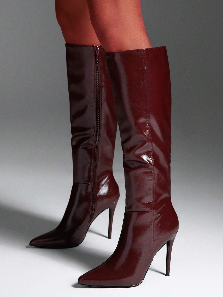 Women's black pointy toe stiletto heel boots featuring a side zipper closure and sleek faux leather finish.