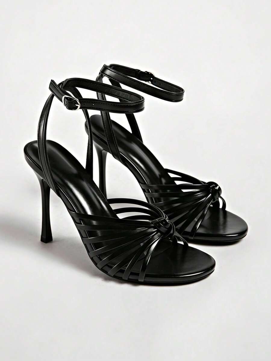 Women's open toe stiletto high heel sandals featuring metallic knot decor and an adjustable ankle buckle strap.
