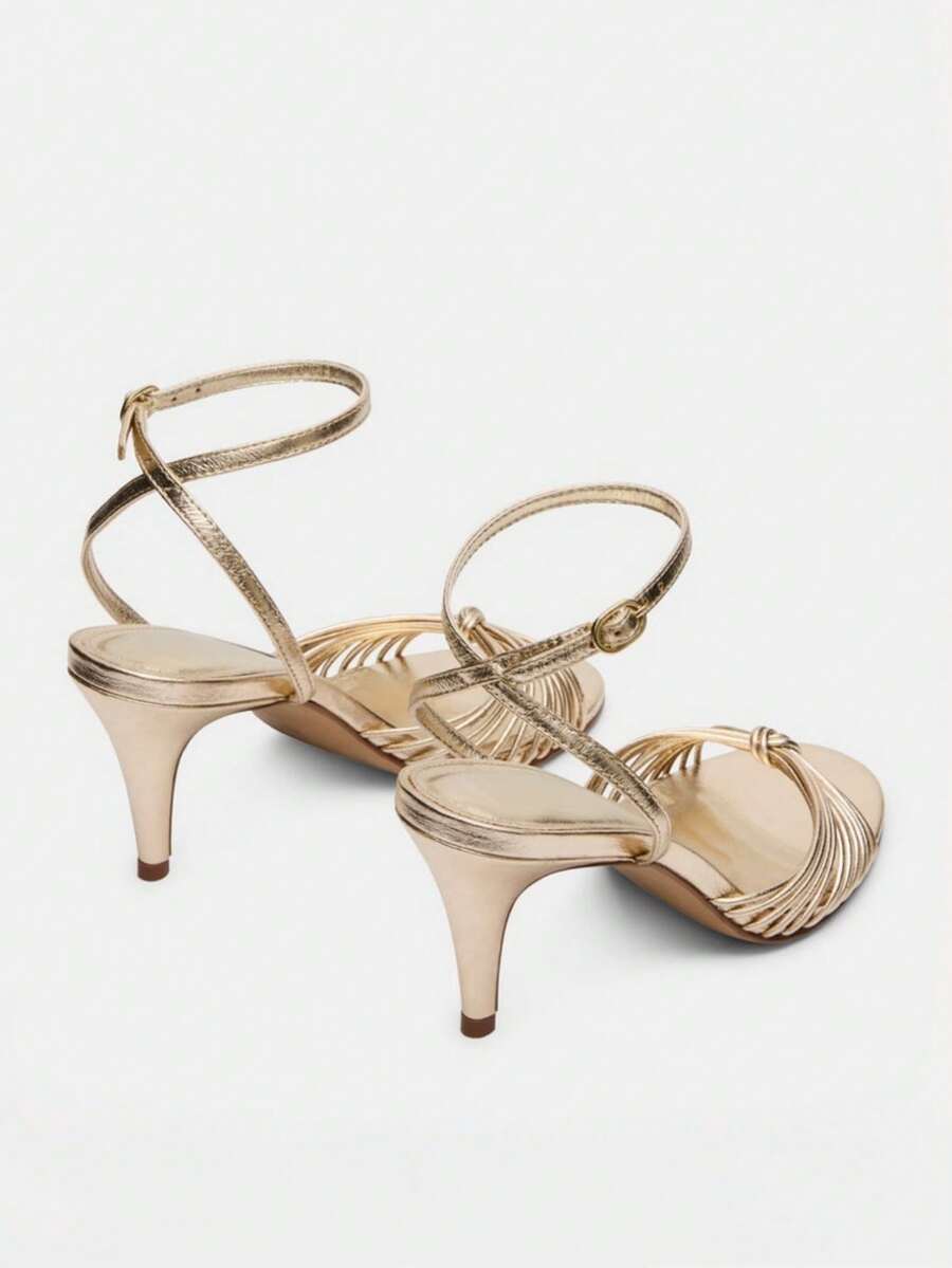 Women's open toe stiletto high heel sandals featuring metallic knot decor and an adjustable ankle buckle strap.