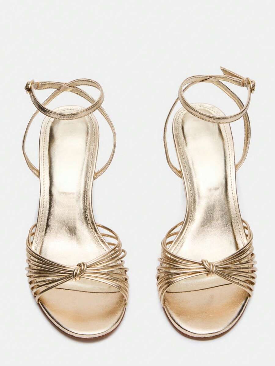 Women's open toe stiletto high heel sandals featuring metallic knot decor and an adjustable ankle buckle strap.