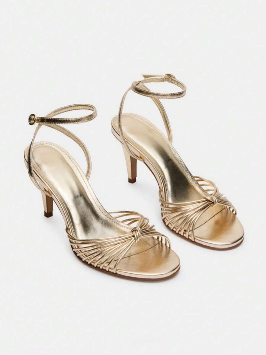 Women's open toe stiletto high heel sandals featuring metallic knot decor and an adjustable ankle buckle strap.