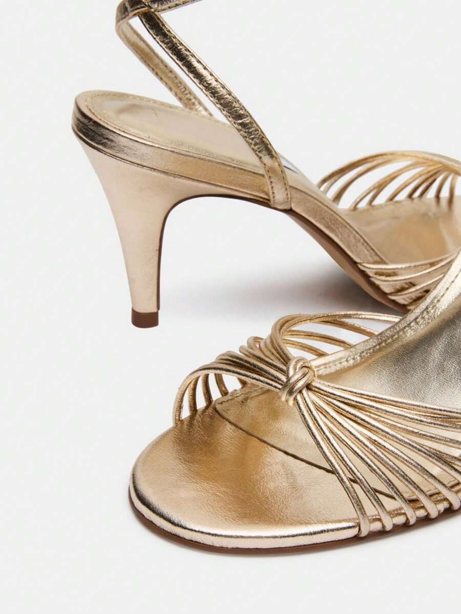 Women's open toe stiletto high heel sandals featuring metallic knot decor and an adjustable ankle buckle strap.